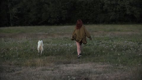 Woman Playing with Her Dog on Green Grass
