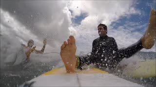 Surfers Collide Catching Wave