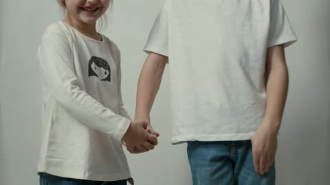 Siblings Posing and Smiling in Front of a Camera