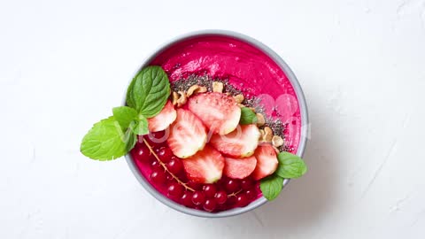 Summer berry smoothie or yogurt bowl with strawberries red currants and chia seeds on white