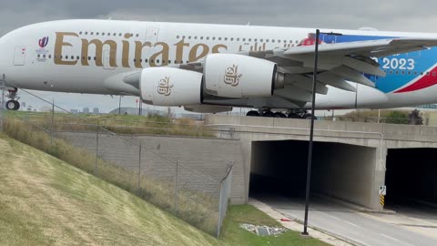 Emirates Airline is passing the bridge and getting ready for take off.