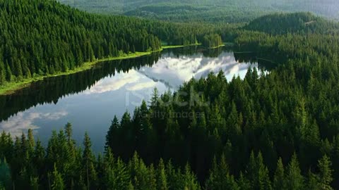 Aerial shot of a lake in the woods reflecting Mount Hood on a quiet roof. Cited in Oregon, USA.