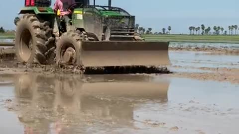Mud field plow with john deere tractor