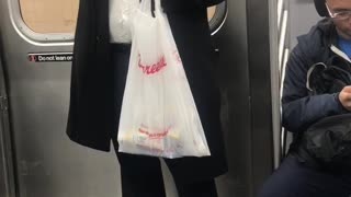 Man drinks out of metal flask on subway train