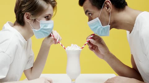 a couples wearing masks an sharing a glass of milkshake hhhhhhhh