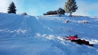 Kid red jacket sleds into other kid