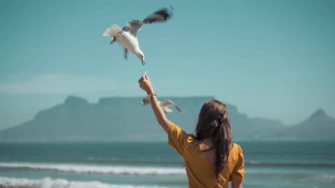 A brave woman is feeding a bird in a different way .