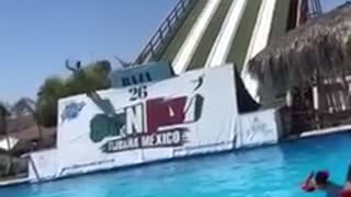 Guys go off of waterslide ramp last guy bellyflops into water