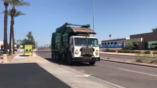 Waste Management Peterbilt 520 front loader driving bye.