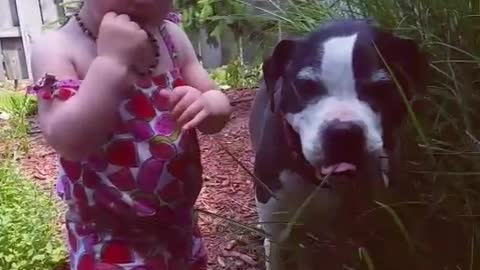 Toddler has a snack with her best friend.