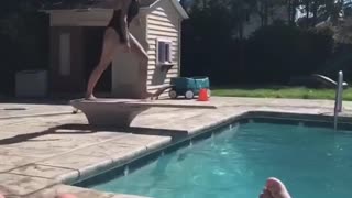 Girl in black bathing suit belly flop into pool
