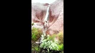 Water cascades down Australia's Uluru