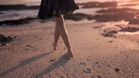 Woman walking barefoot on the shore
