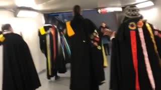 People dressed in medieval clothing walk through subway station