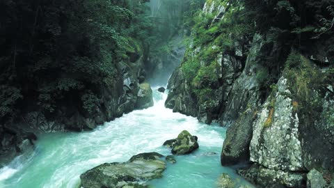 Stunning waterfall scenery flowing between rocks and trees, filmed in 4K resolution