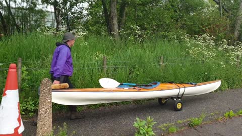 Pushing a sea kayak through the centre of a town in Scotland