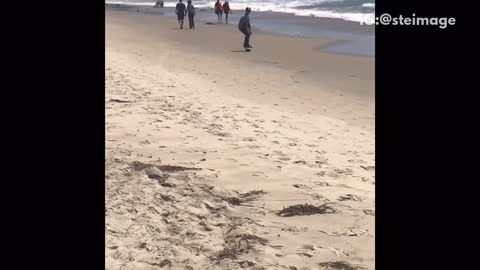 Guy riding uniboard hoverboard beach riding dirty