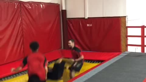 Woman bounces off of trampoline with two friends and face plants into the floor
