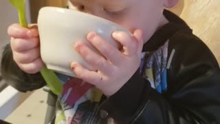 Cute baby drinks soup