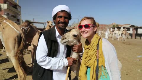 Female tourist with local man at Camel market