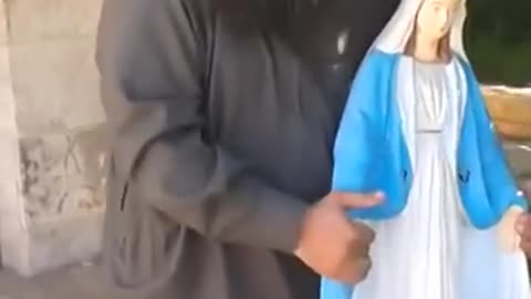 Muslim migrant smashing a statue of Virgin Mary