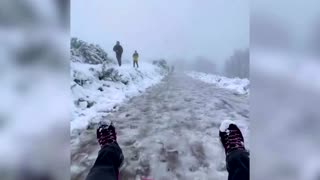 Tobogganist enjoys snowy conditions on hillside path