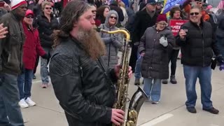 Saxophonist Plays National anthem in street during Milwaukee protest