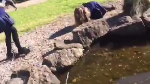 Girl in blue school uniform falls on rocks
