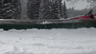 Skier with helmet goes downhill on ramp and ends up falling down