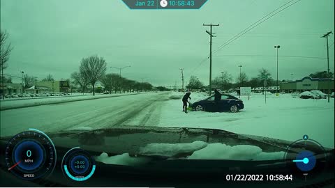Man Helps Shovel Out Car Stuck at Intersection