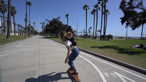 Girl skateboards with Pomeranian in her backpack