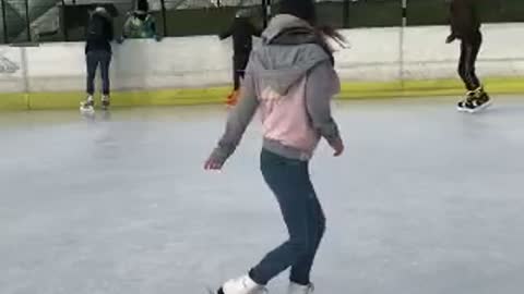 Girl in pink spins on ice spins and falls slow motion
