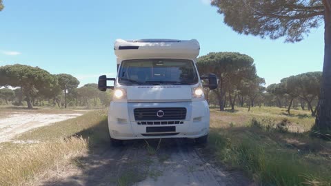 A Camper Van Driving on an Unpaved Road