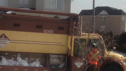 Garbage Man Shoveling Snow Into The Truck