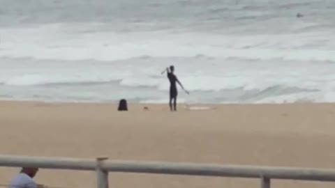 Man in wet suit play with nunchucks