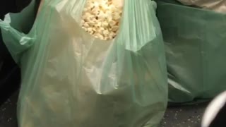 Woman eating popcorn from green bag