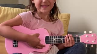 Five year old giving ukulele lesson