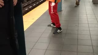 Man in orange air guitar on subway platform