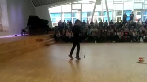 Boy performing crazy yoyo skills in front of the school.
