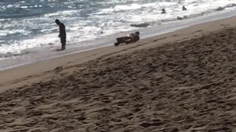 Man rolls down sand towards beach