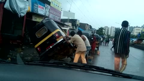 Man lifts rickshaw to help clean