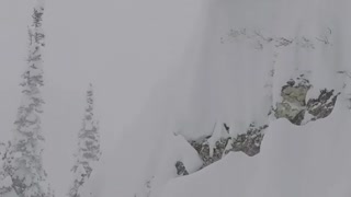 WHERE DID HE GO? Dude skis off high ledge into deep snow.