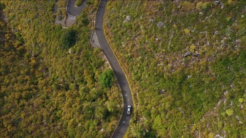 top view of the surface of the island of tenerife car drives on a winding mountain road in a desert