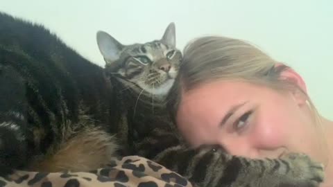 Cute cat pushes woman’s head down to use as a pillow
