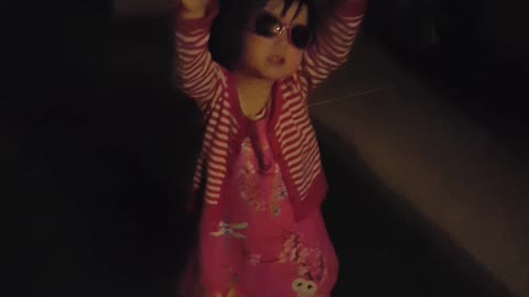 girl wearing sunglasses singing twinkle little star at night