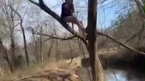 Guy tries to swing on vine over a river, vine breaks and guy falls into water