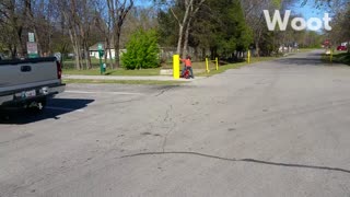 Little boy red shirt rides bike off path into yellow pole