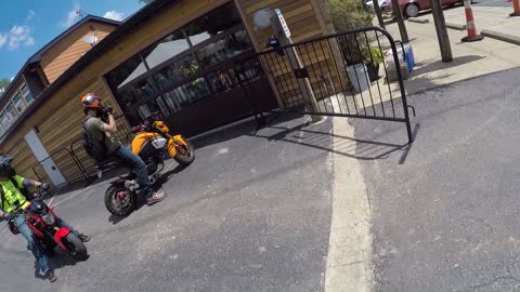 Rider Wheelies into Metal Fencing by Restaurant