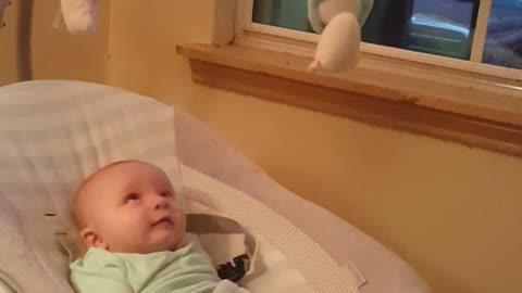 Adorable baby cooing and talking to his reflection