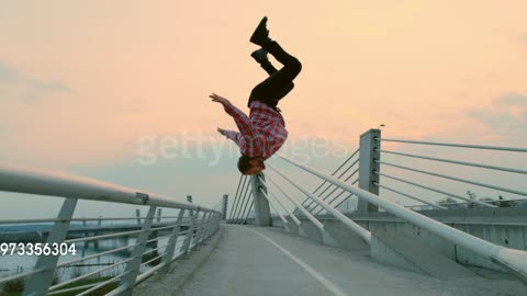 SLO MO B-boy performing a somersault from a fence